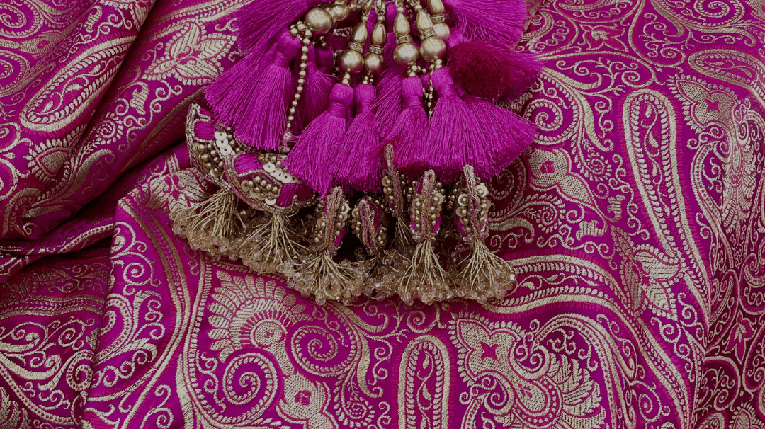 Pink Indian textile with a pink and gold tassel