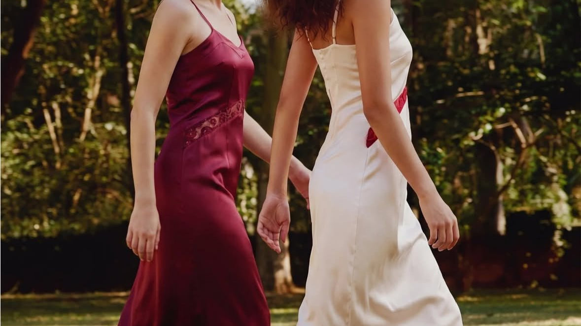 two women walking in satin dresses