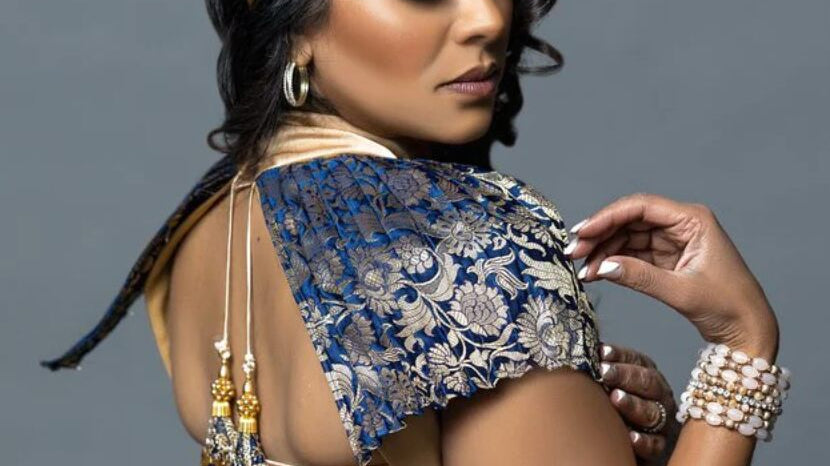 a woman in a gold dress with a blue patterned sleeve detail