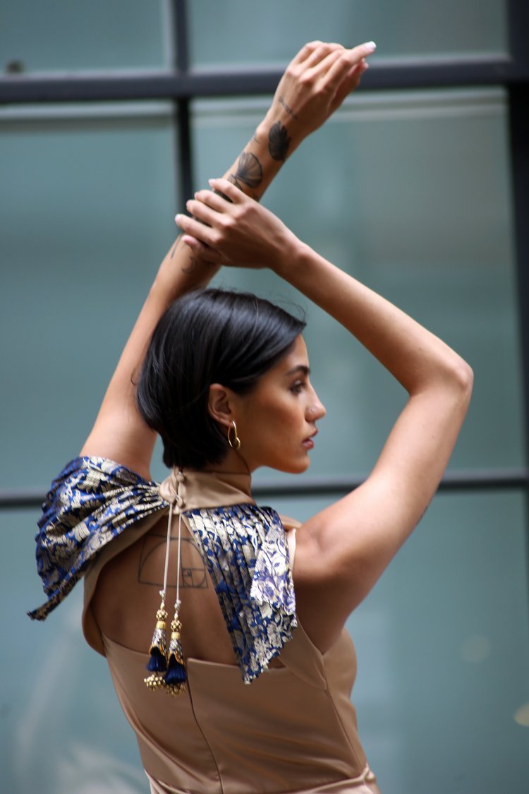 Woman with a patterned scarf on her shoulder against a glass wall background