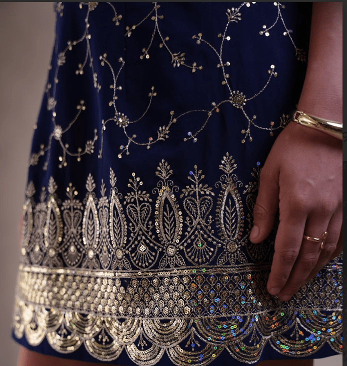 Navy blue dress with intricate gold embroidery and embellishments.