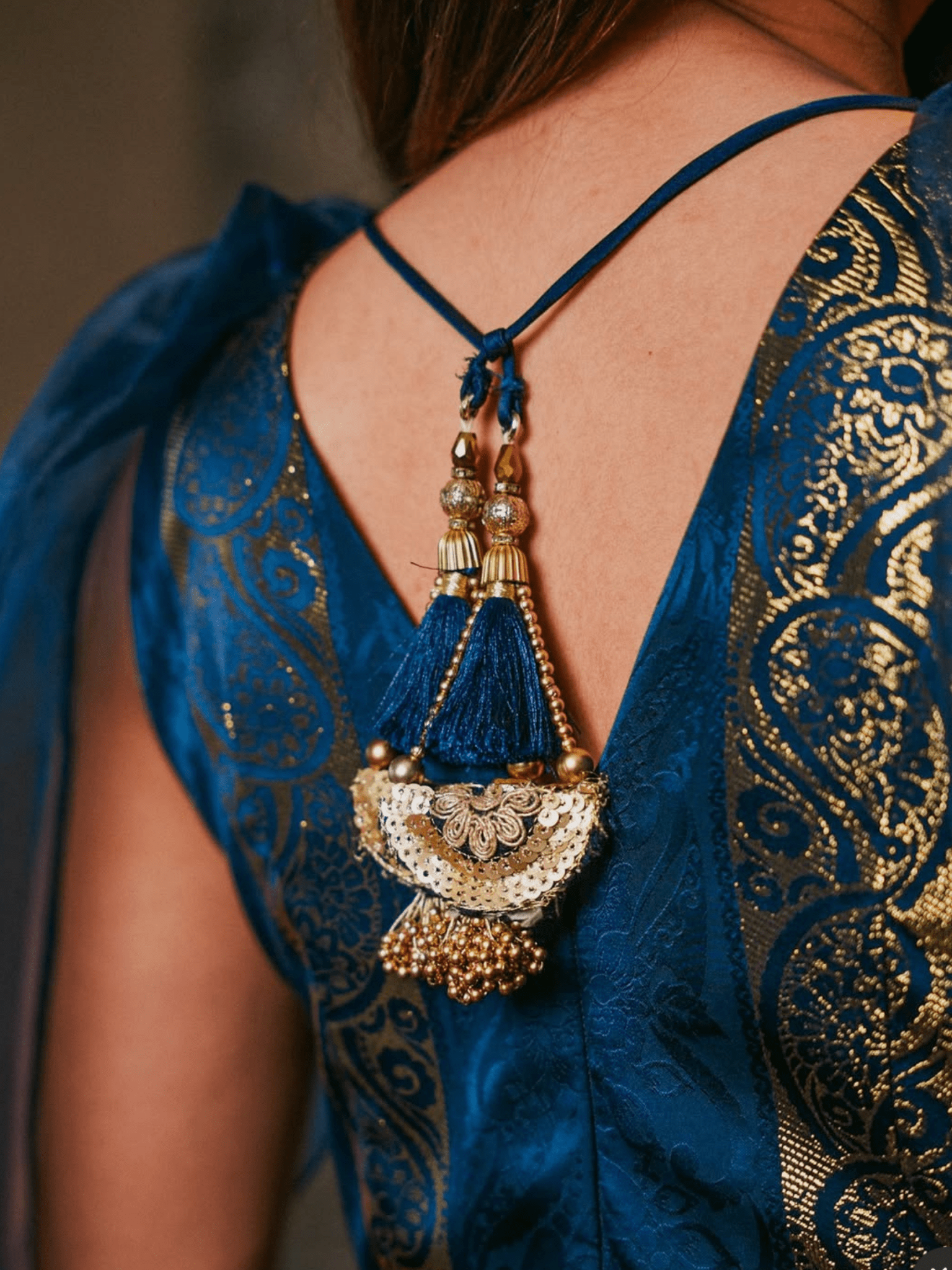 Blue embroidered garment with a decorative necklace