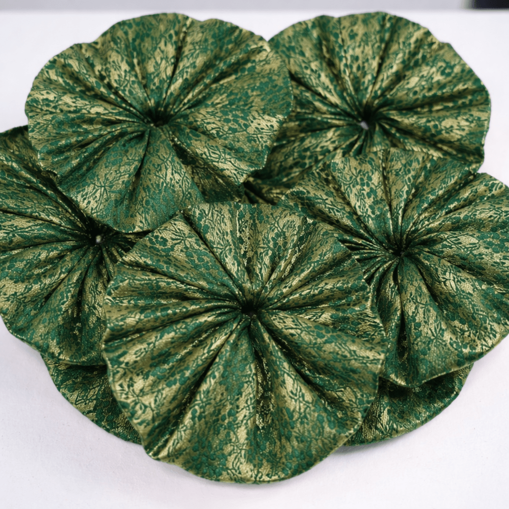 Green textured fabric flower on a white background