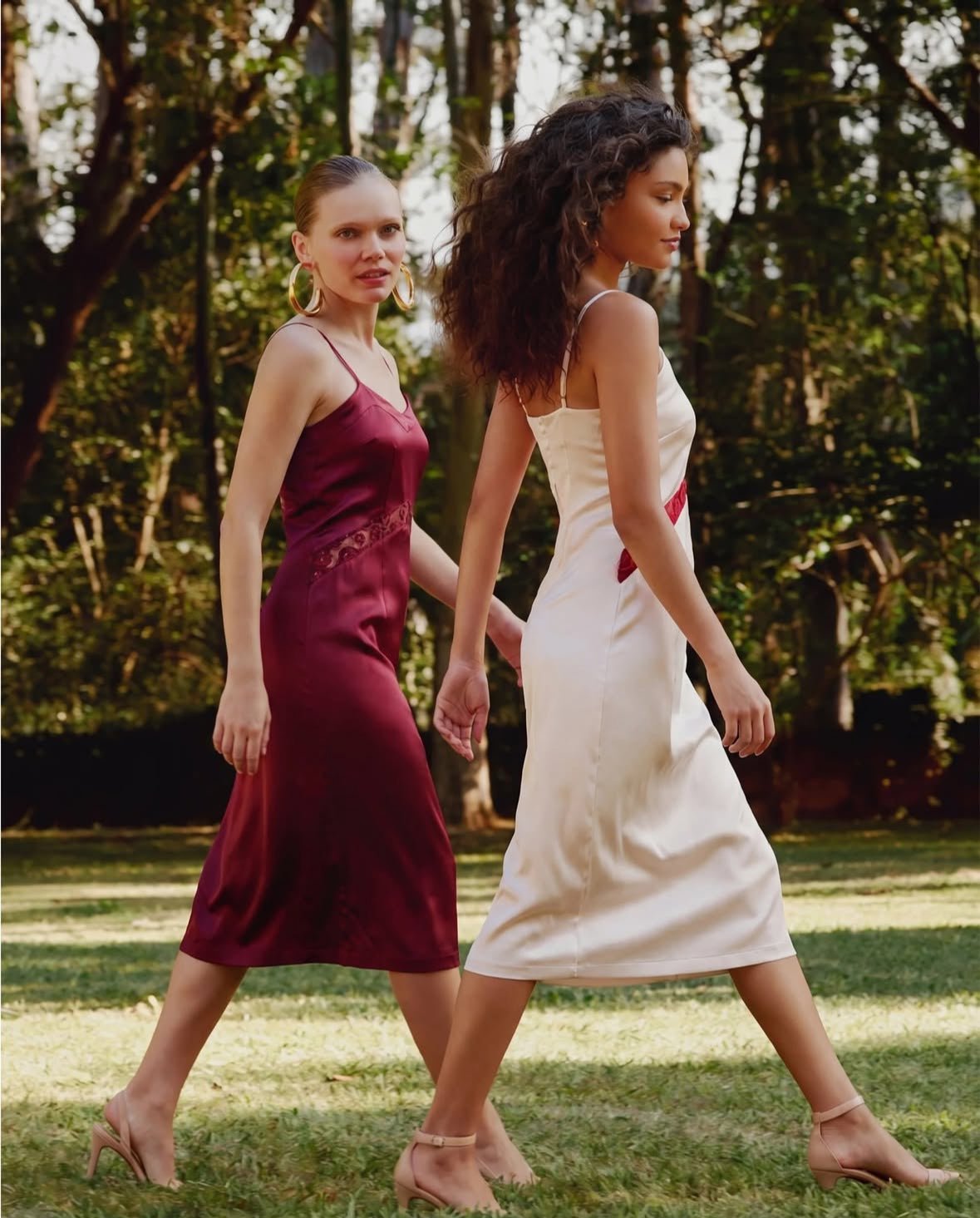 two women walking in satin dresses