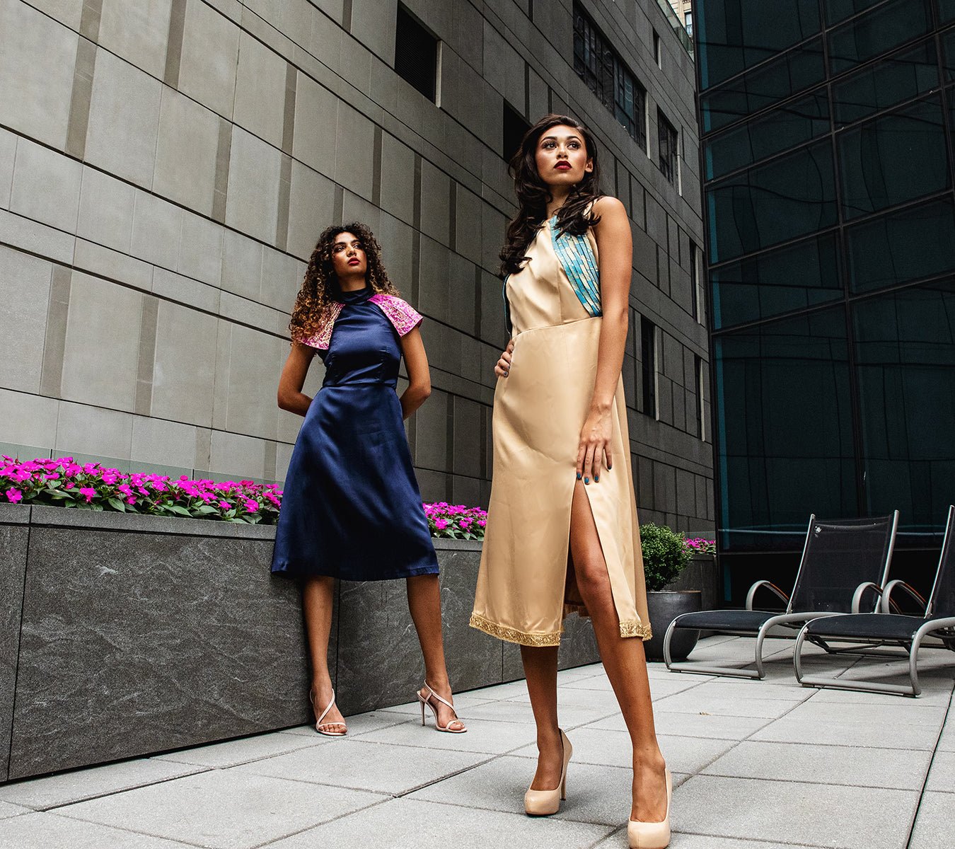 two women standing on a roof in coctail dresses