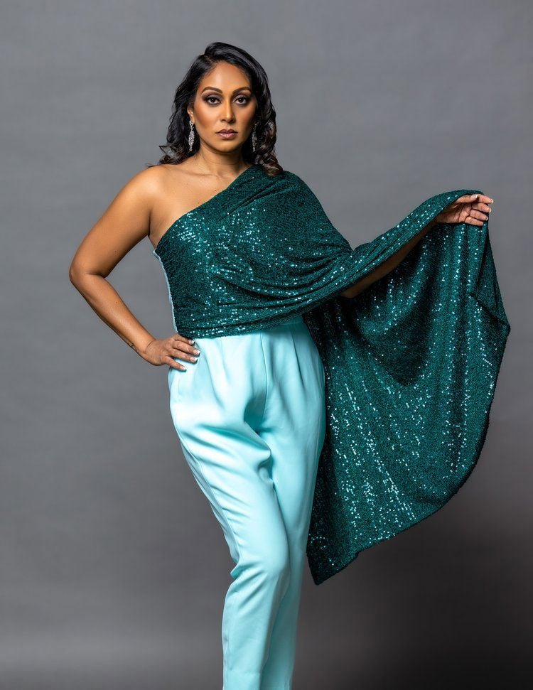  a model in a blue jumpsuit with sequin cape detail