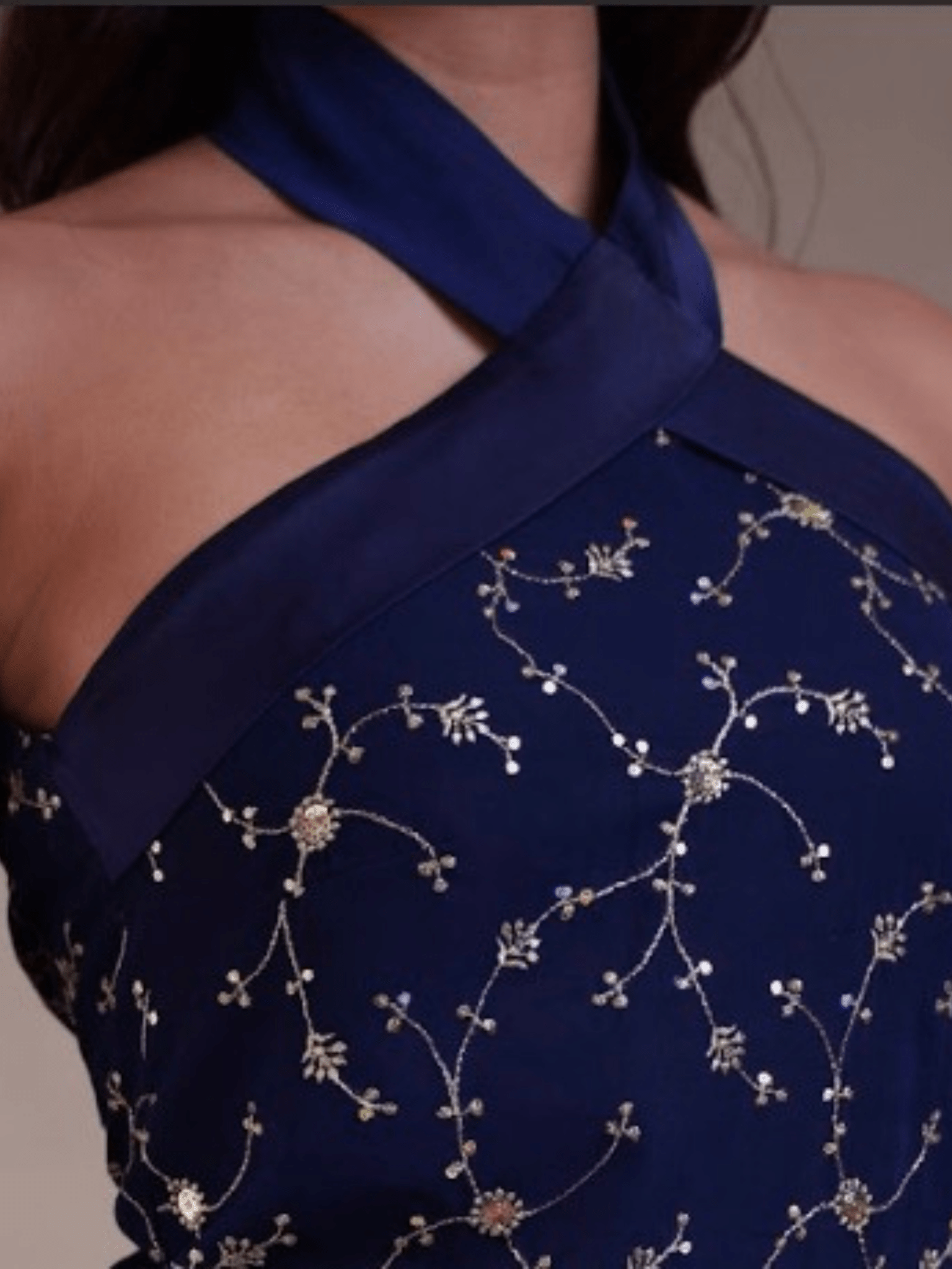 Navy blue dress with floral embroidery on a neutral background