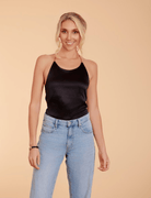 a model in light denim and a black satin halter neck top