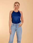 a model in light denim and a blue satin halter neck top