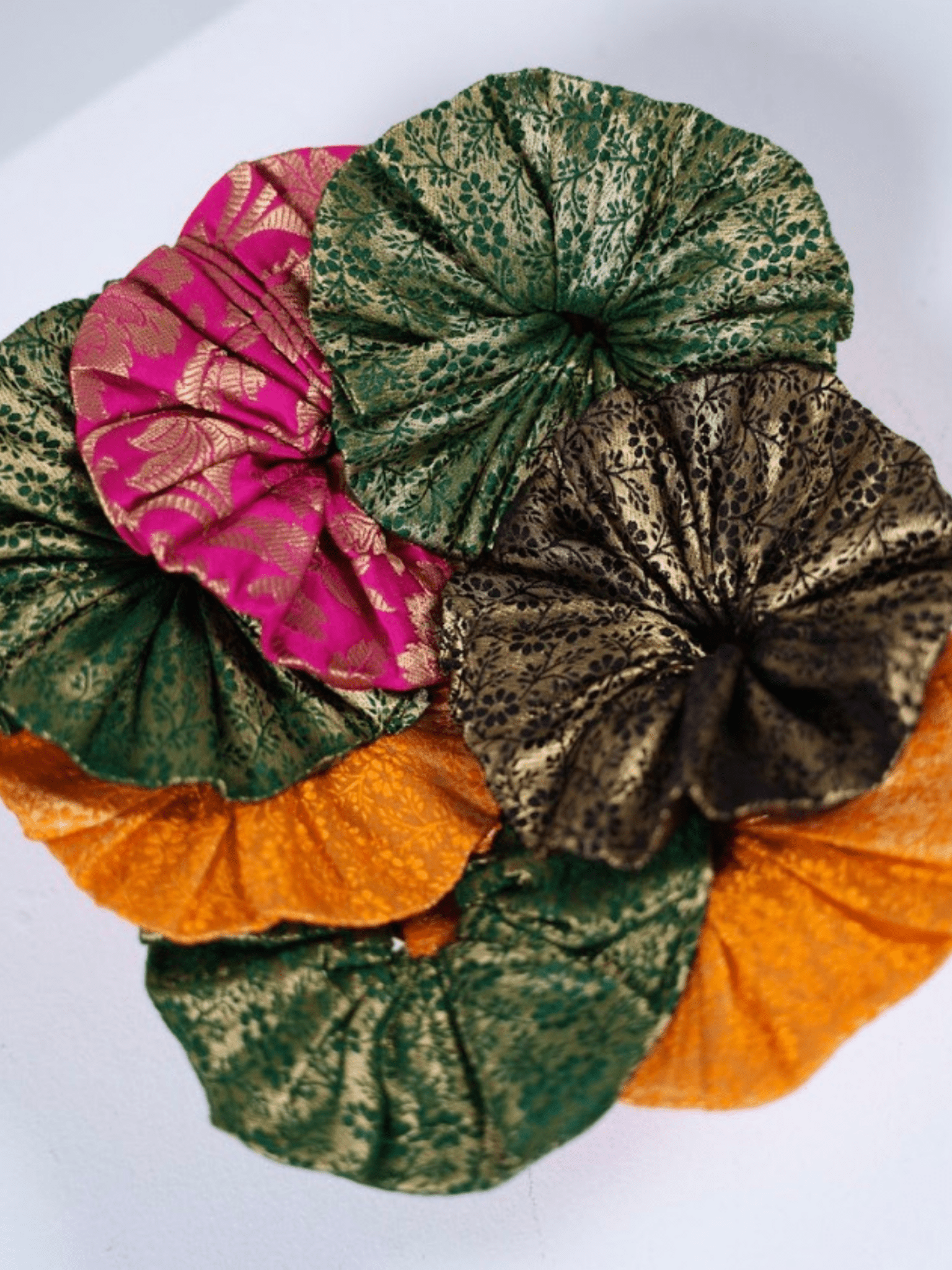 Three colorful fabric turban styles on a white background