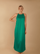 Woman wearing a green dress against a beige background