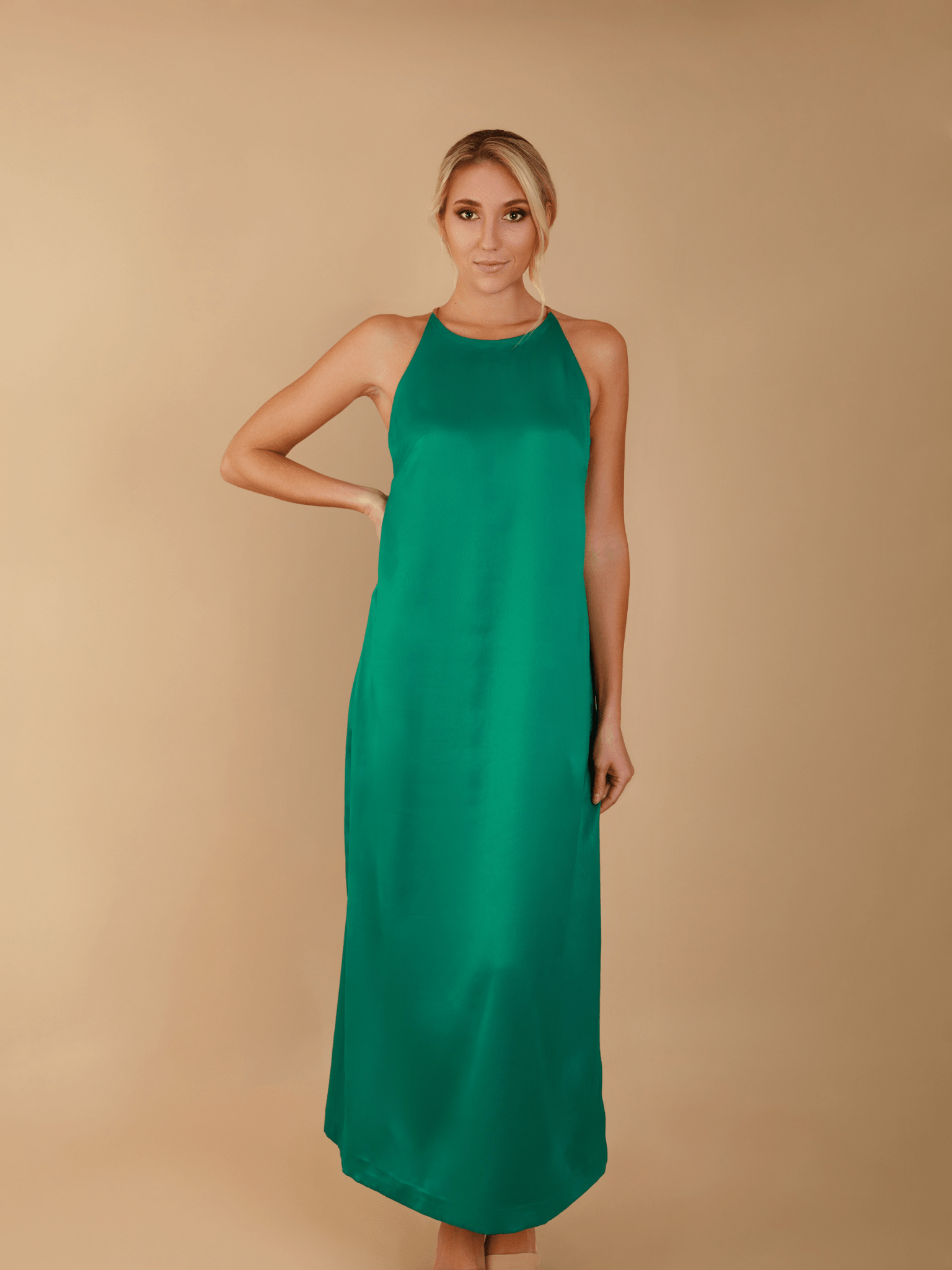 Woman wearing a green dress against a beige background