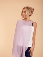 Woman wearing a light purple scarf over a white top on a beige background