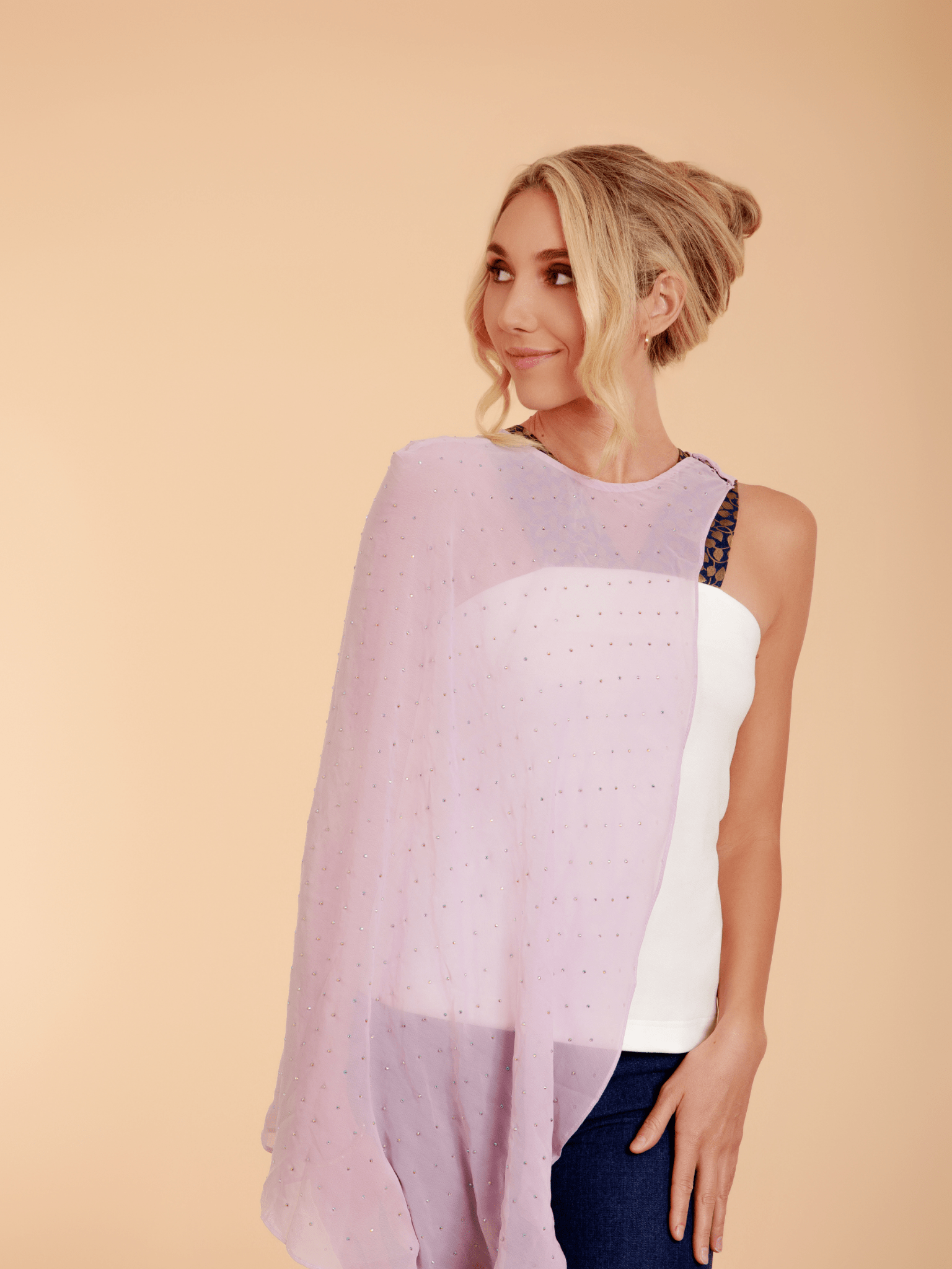 Woman wearing a light purple scarf over a white top on a beige background