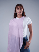 Woman wearing a white t-shirt and blue jeans with a light purple scarf over her shoulder on a gray background