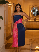 Woman wearing a strapless dress with pink and navy design in an indoor setting