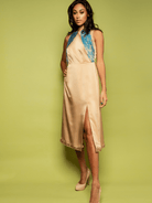 Woman wearing a beige dress with blue embroidery on a green background