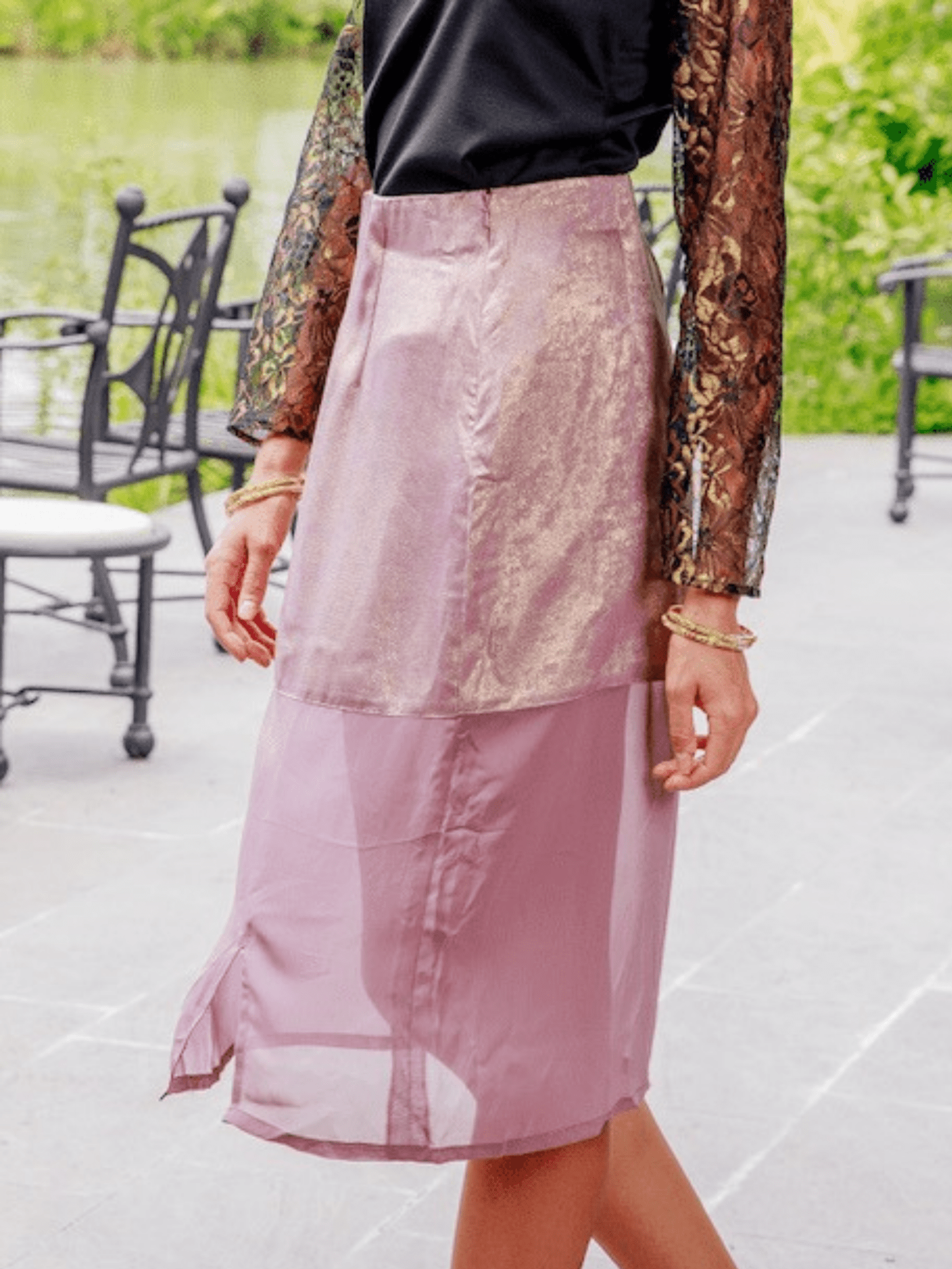 Person wearing a pink skirt with a blurred outdoor background