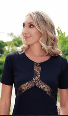 a close-up image of a model in a black lace dress