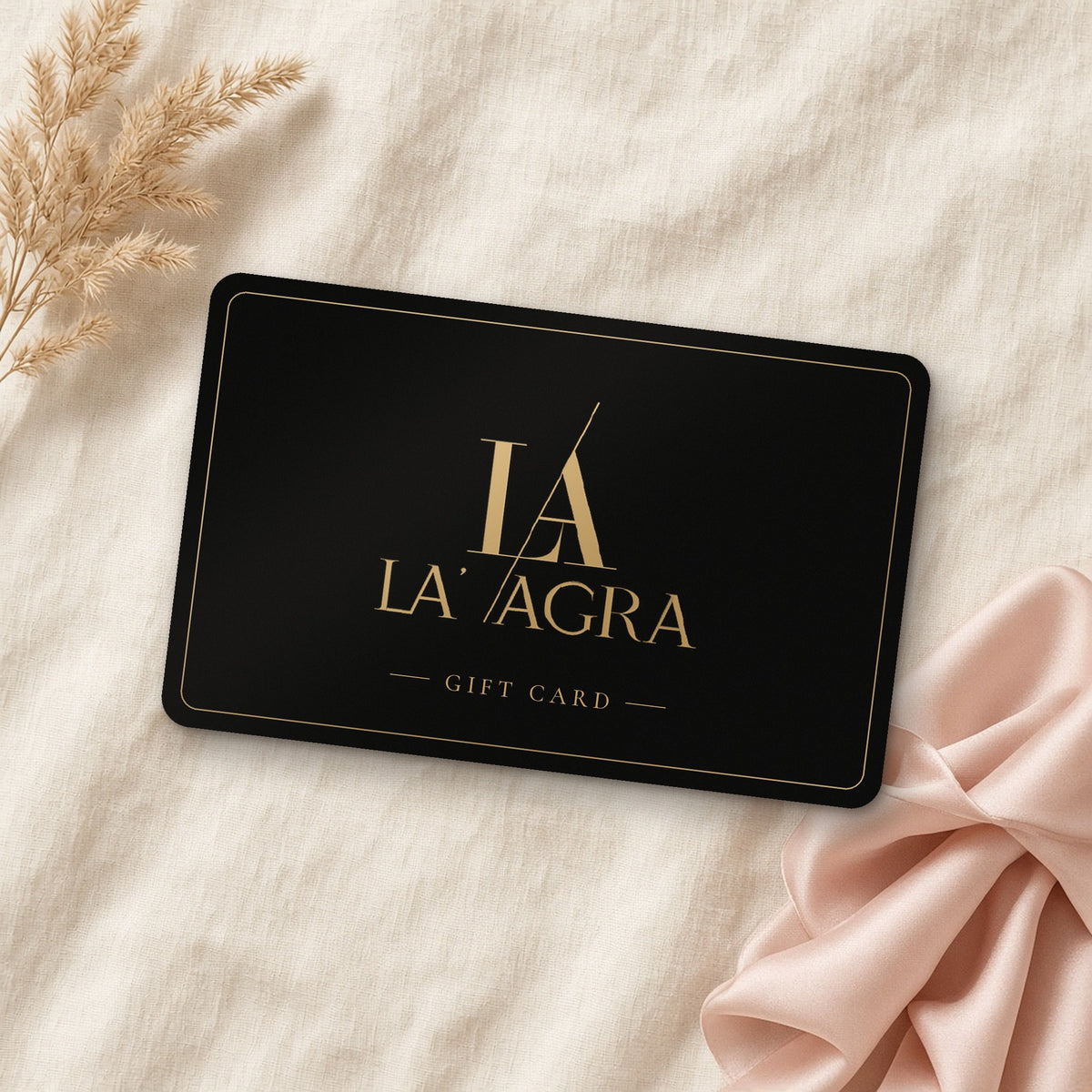 La' Agra gift card: black card with the gold La' Agra logo and the words Gift Card, on cream linen