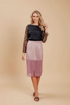 a model in a lace blouse and a pink skirt