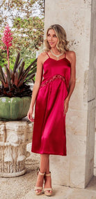 a model in a red satin midi dress