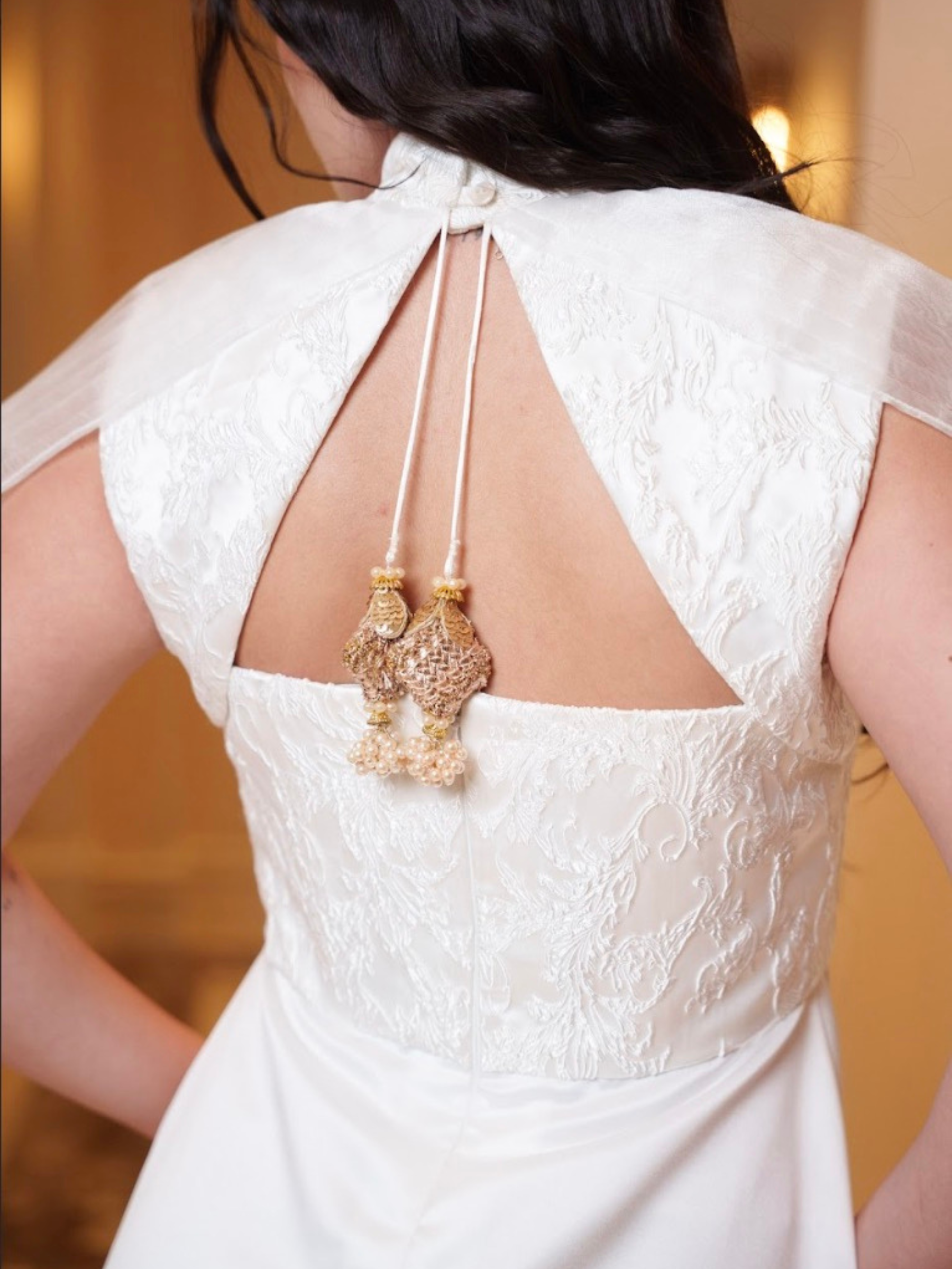 White lace dress with cut-out back and decorative elements